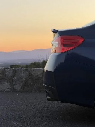 A car tail light at sunset with mountains behind