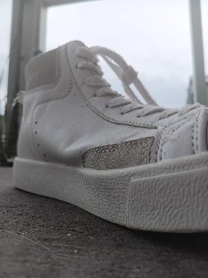 A white high-top sneaker from a low angle