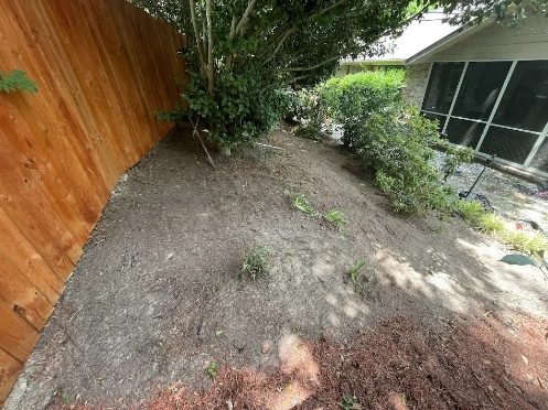 Bare dirt along a fence before any work
