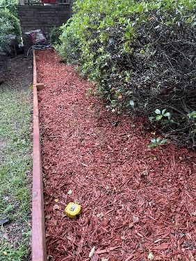 A mulched bed along a fence, finished